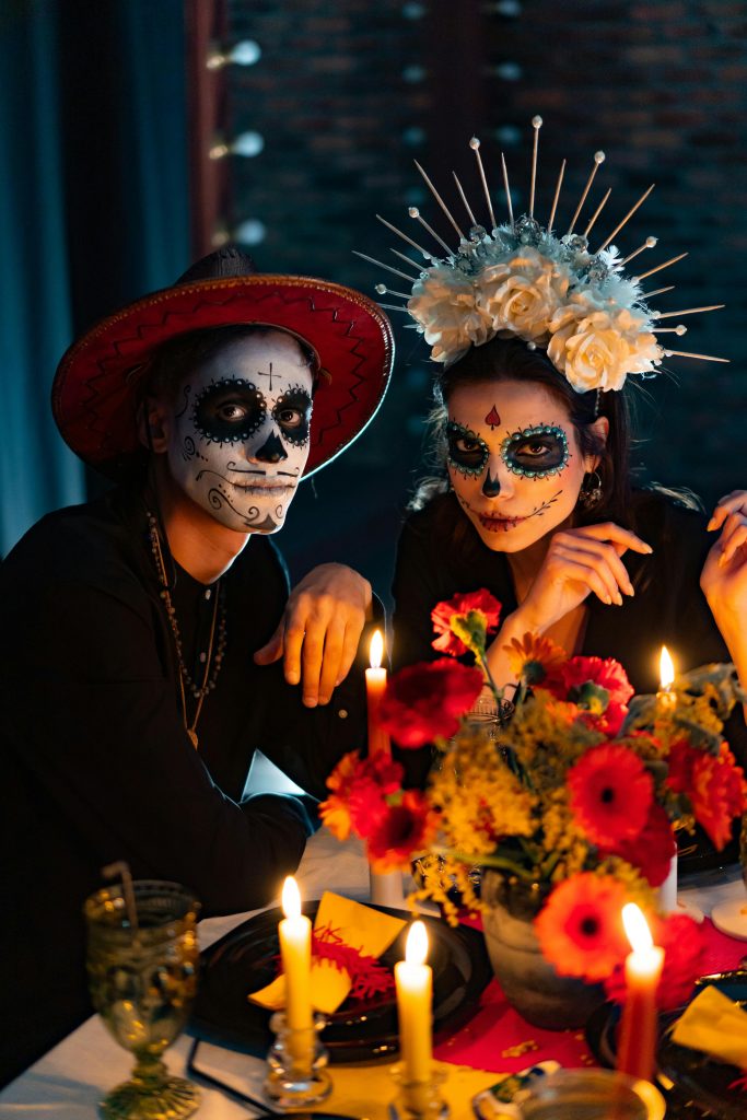 Vibrant Day of the Dead celebration featuring traditional makeup and costumes at a candlelit dinner.